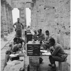 _A_company_of_men_has_set_up_its_office_between_the_columns_-Doric-_of_an_ancient_Greek_temple_of_Neptune,_built_about_7_-_NARA_-_531170.tif